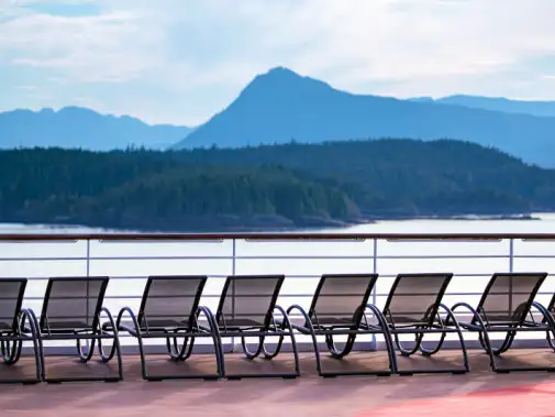 A row of empty lounge chairs on the deck ready for you to relax, overlooking the tranquil lake  and forested hills, perfect for bear watching.1.jpg