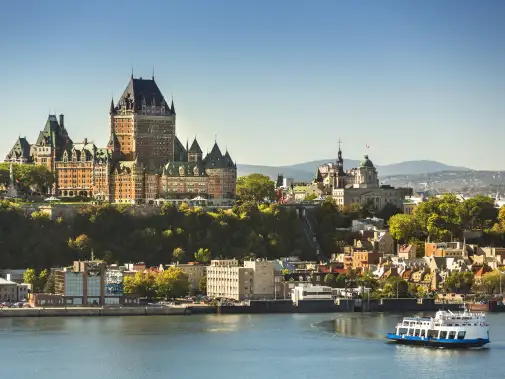 A scenic view of old Québec City with the iconic Fairmont Le Château Frontenac towering above the historic architecture