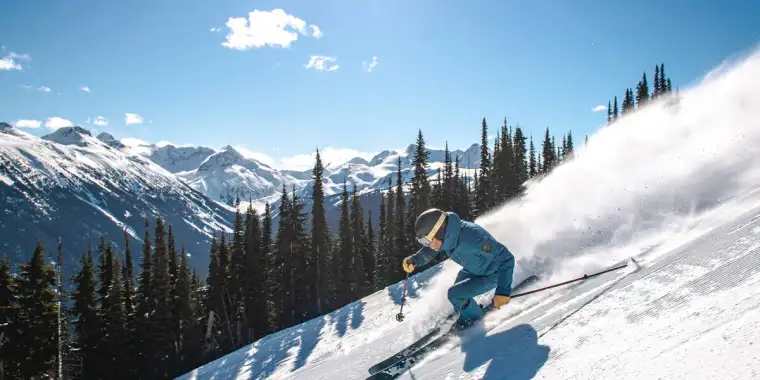 A skier descending a steep slope in Whistler ski resort