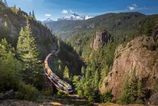 Rocky Mountaineer train travelling through a scenic canyon in the Canadian Rockies
