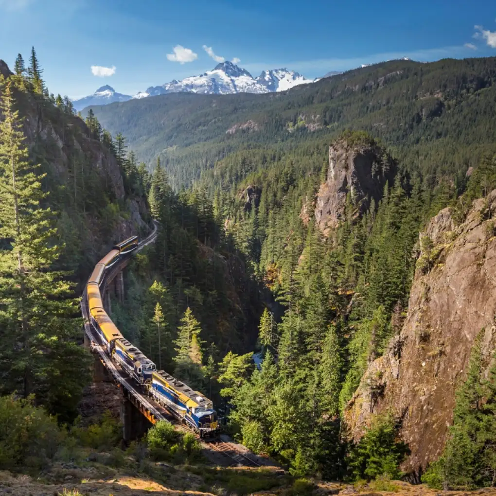 Rocky Mountaineer train travelling through a scenic canyon in the Canadian Rockies