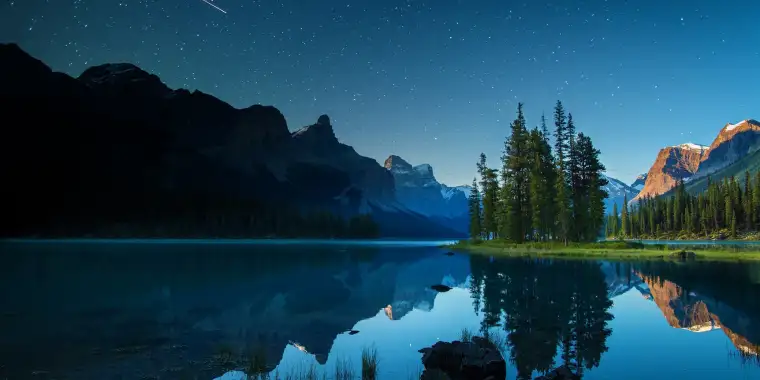 Maligne Lake at dusk reflecting a starry sky