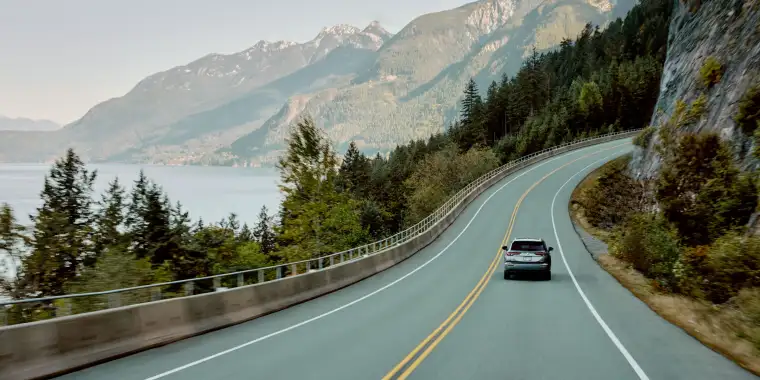 a car drives on the sea-to-sky highway in British Columbia