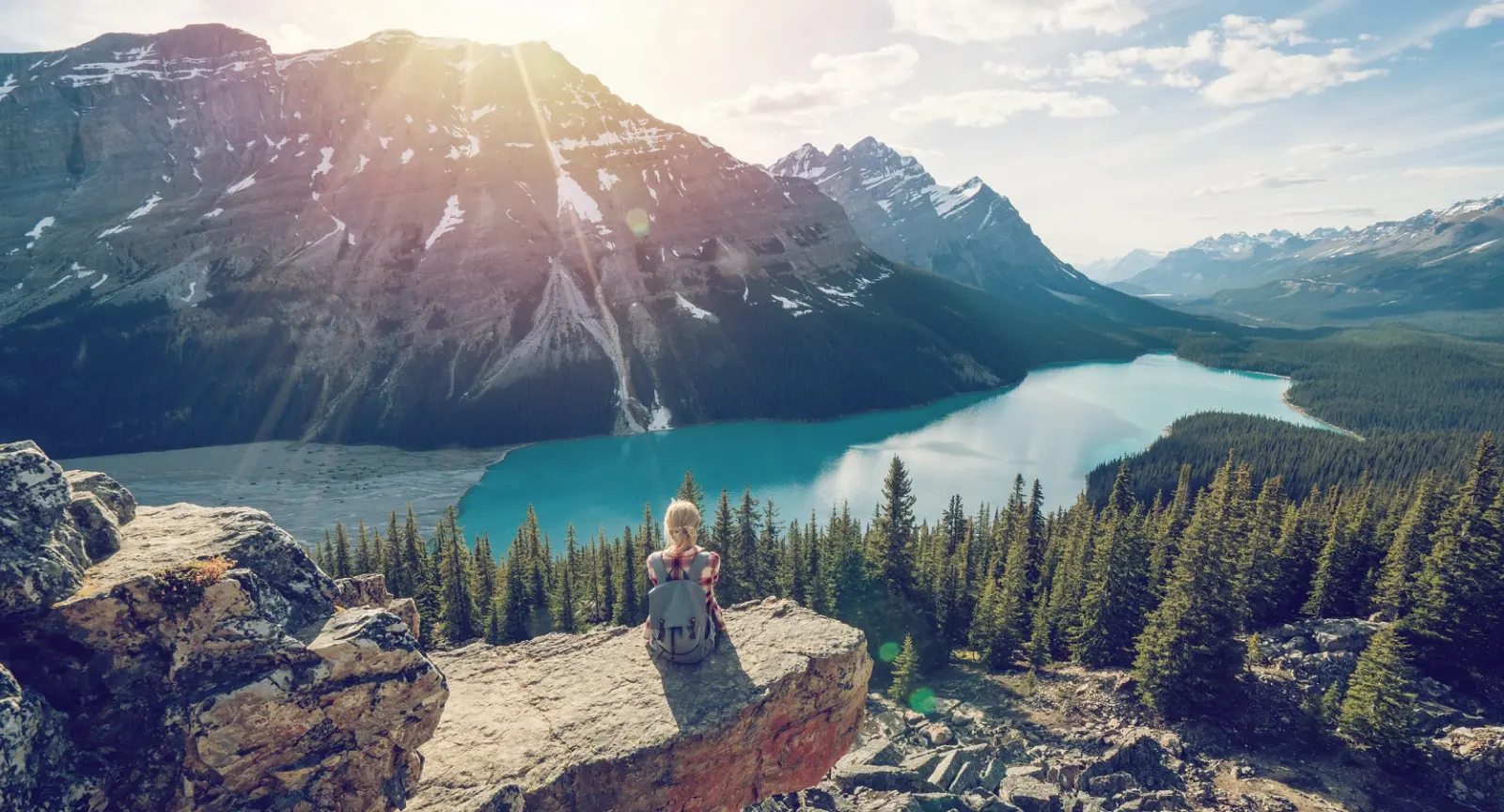 A woman sits and enjoys a scenic view of the Canadian Rockies