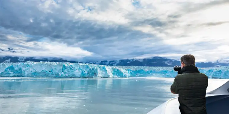 A man photographs the Hubbard Glacier from a cruise ship